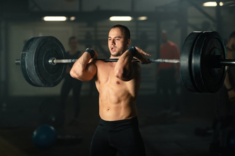1-RM-Rechner: Maximalkraft aus Gewicht und Wiederholungen schätzen Sportler trainiert mit der Langhantel im Fitnessstudio